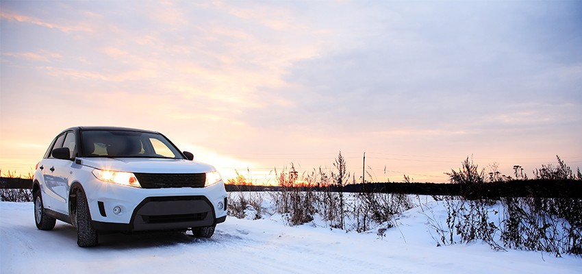 Vehicle-on-Snowy-Road-at-Sunrise